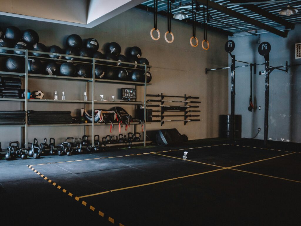 Spacious gym interior featuring gymnastic rings, kettlebells, and medicine balls, perfect for fitness enthusiasts.